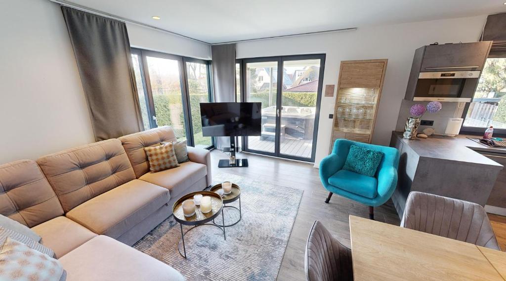 ein Wohnzimmer mit Sofa und Fernseher in der Unterkunft Ocean House Garten Eden mit Whirlpool in Timmendorfer Strand