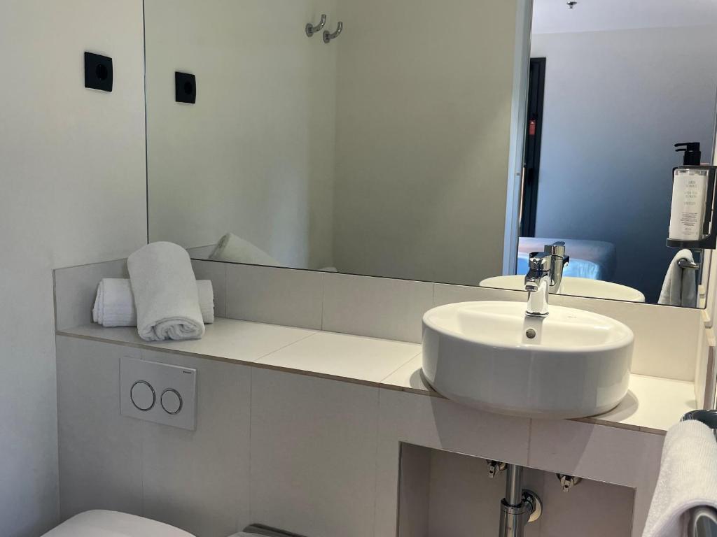 a white bathroom with a sink and a mirror at Hs Madrid Centro Atocha in Madrid