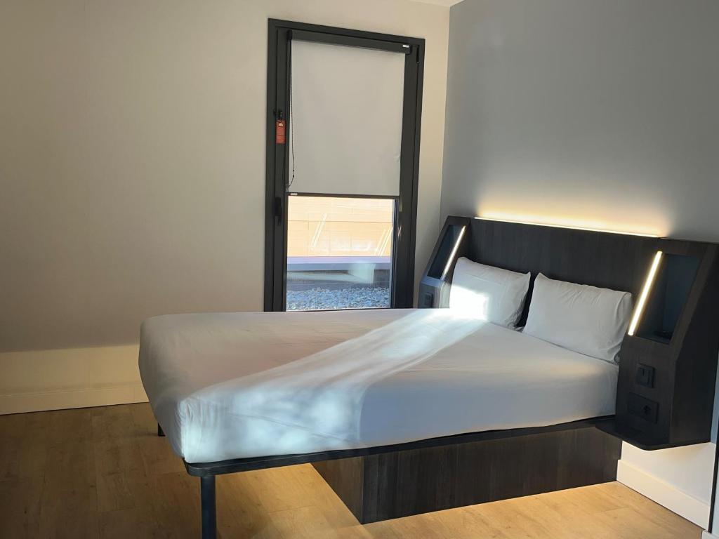 a bedroom with a white bed with a window at Hs Madrid Centro Atocha in Madrid