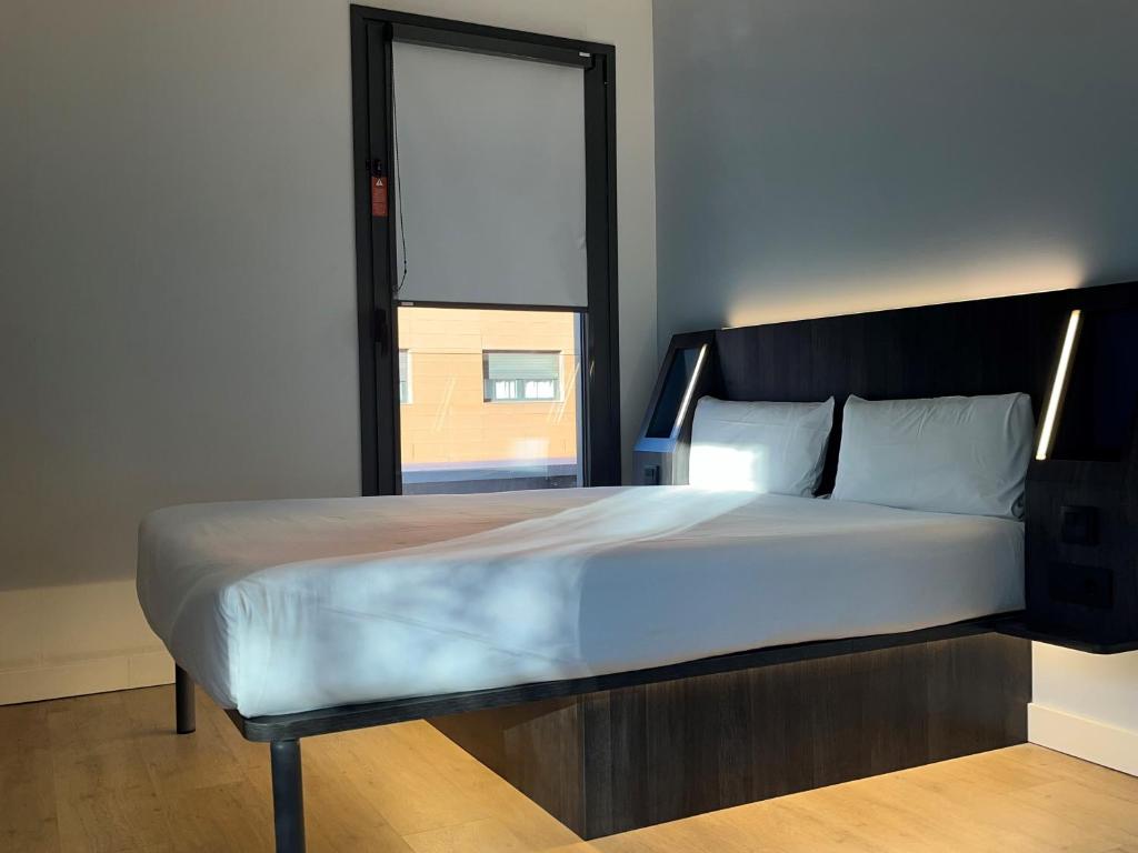 a bedroom with a large bed with a window at Hs Madrid Centro Atocha in Madrid