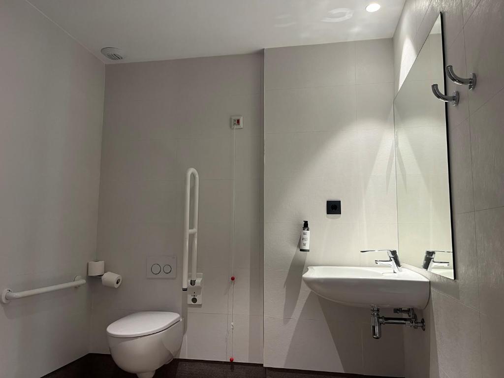 a white bathroom with a toilet and a sink at Hs Madrid Centro Atocha in Madrid