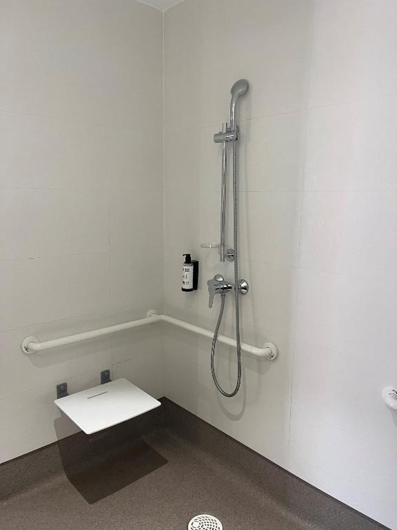 a bathroom with a shower with a bench in it at Hs Madrid Centro Atocha in Madrid