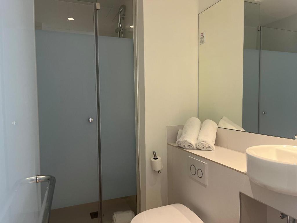 a bathroom with a sink and a toilet and a mirror at Hs Madrid Centro Atocha in Madrid
