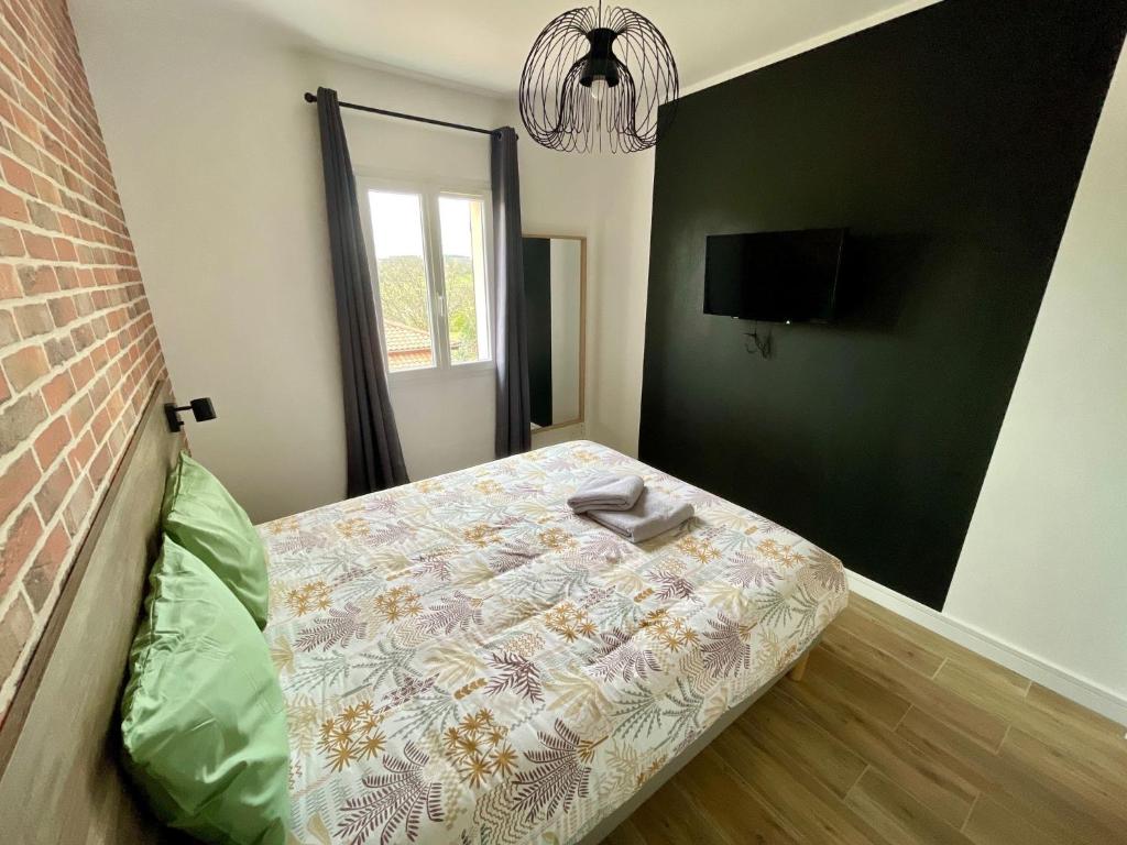une petite chambre avec un lit et une télévision dans l'établissement Le N4 des Hauts de SARLAT, Clim Piscine Parking, à Sarlat-la-Canéda