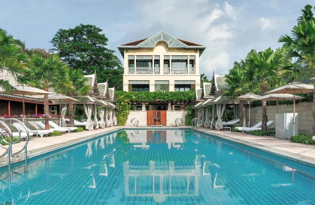 a house with a swimming pool in front of a house at The Peninsula Bangkok in Bangkok