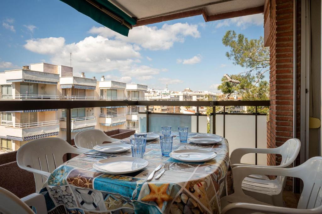a table on a balcony with a view of a city at AT139 Els Pins, 1ra línea de la playa, piscina, airco, in Torredembarra