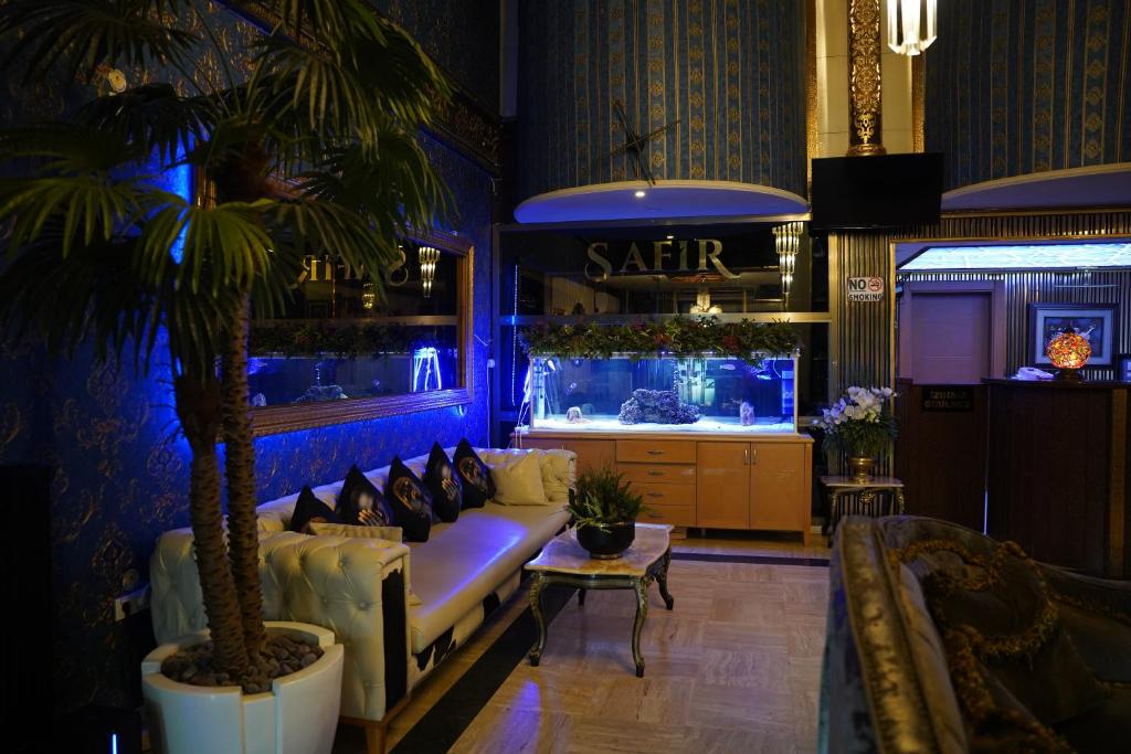 a living room with a couch and a palm tree at Safir Hotels Silivri in Silivri