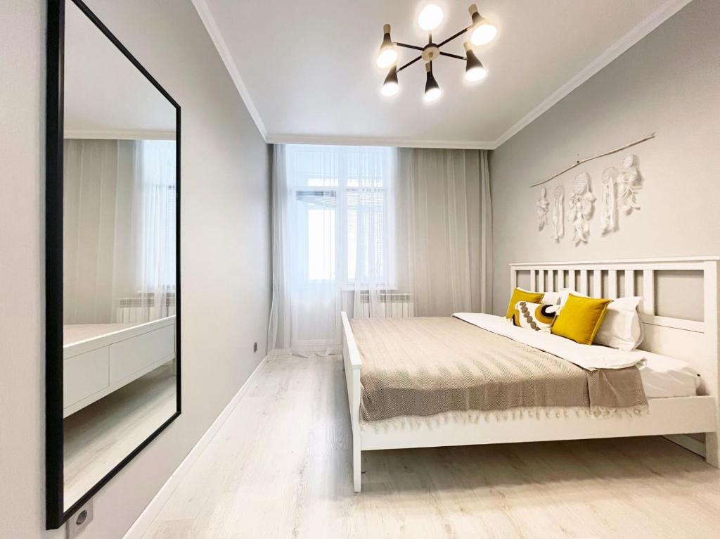 a bedroom with a bed and a large mirror at Просторная евродвушка люкс на Левом берегу Астаны in Astana