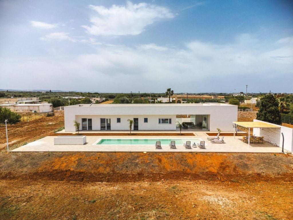 een villa met een zwembad in een veld bij Villa Donnosanto a 5 Minuti Da Spiaggia. Ostuni 10 in Carovigno