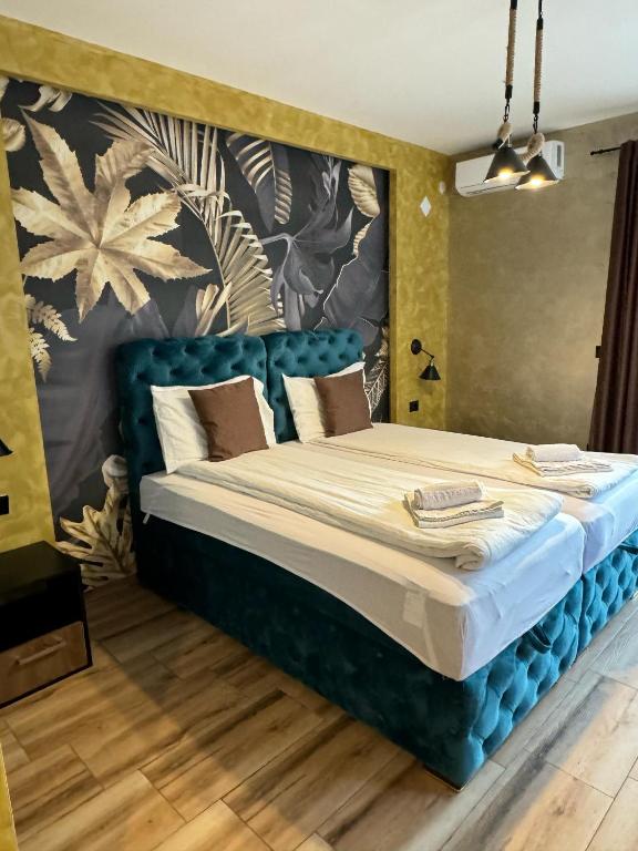 un letto con testiera blu in una stanza di ATOS Srebrno jezero - Villa and Restaurant a Veliko Gradište