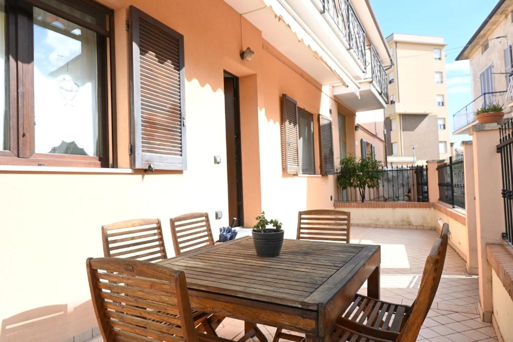 ein Holztisch und Stühle auf einer Terrasse in der Unterkunft SE160 - Senigallia, comodo trilocale con patio in Senigallia