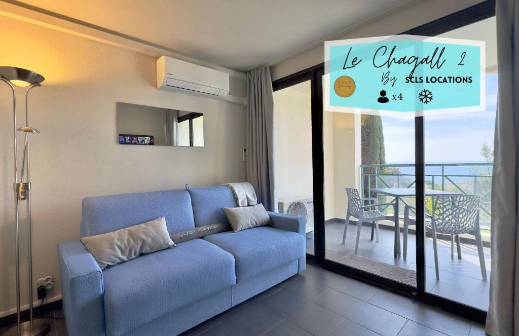 un salon avec un canapé bleu et un balcon dans l'établissement Le Chagall 2 SCLS Locations, à Cannes