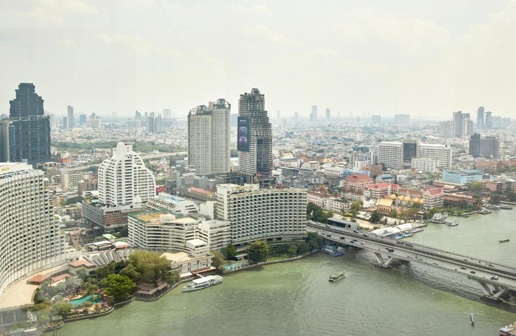 an aerial view of a city with a river and buildings at The Peninsula Bangkok in Bangkok