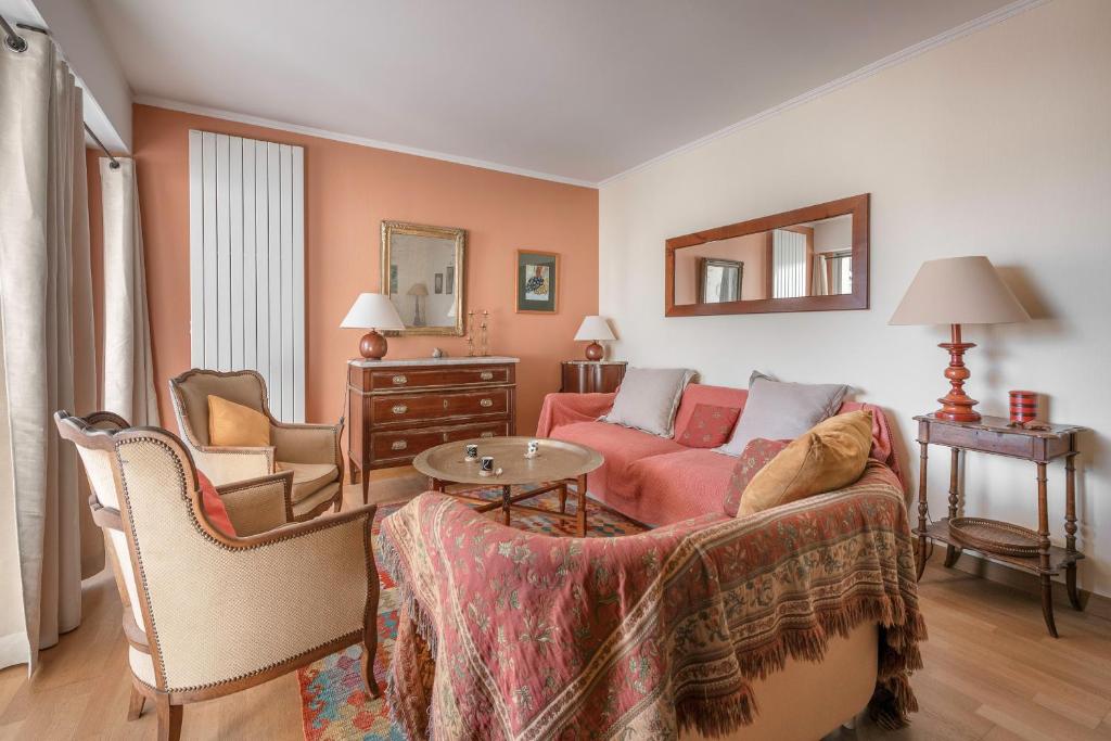 a living room with a red couch and chairs at Appartement pour 4 au Pouliguen, avec terrasse in Le Pouliguen