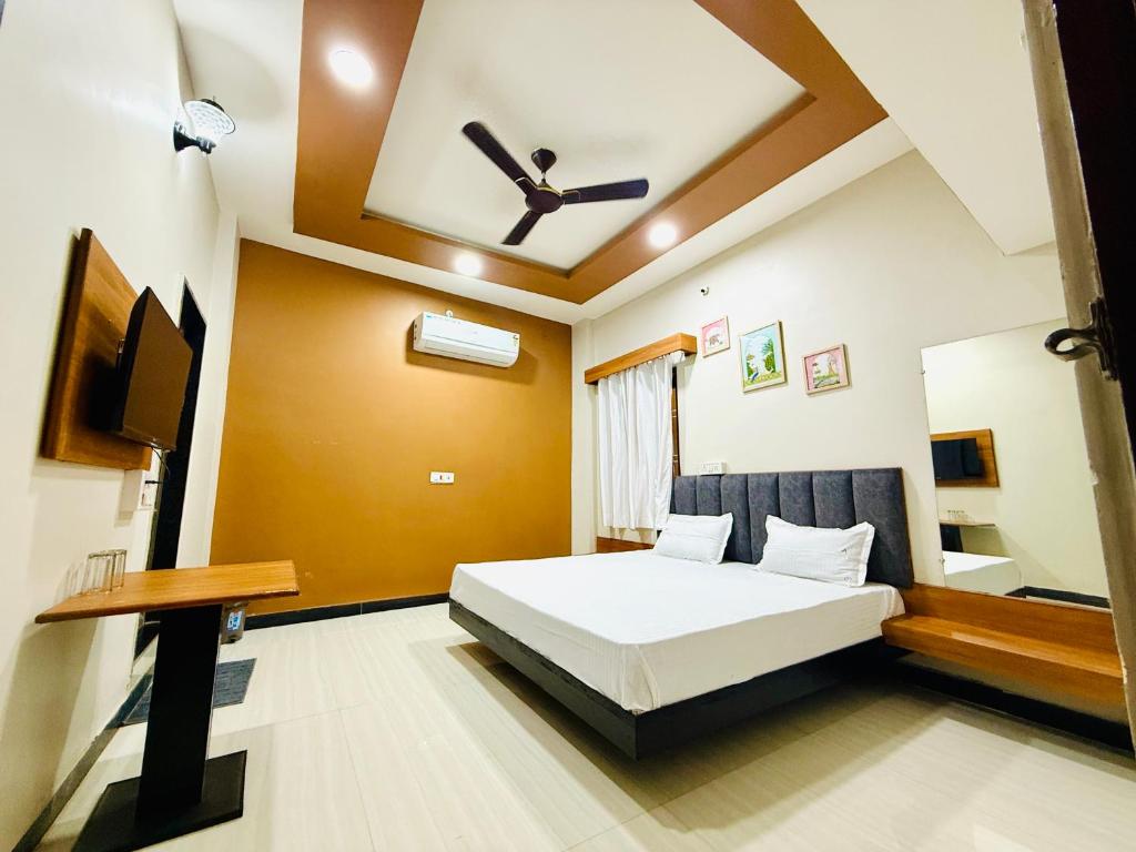 a bedroom with a bed and a tv in it at Vrindas Home Stay in Maheshwar