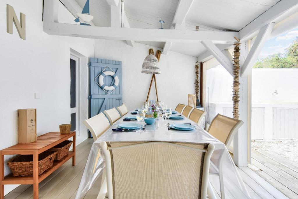 une salle à manger avec une table et des chaises dans l'établissement Maison pour 8 - 100 m de la plage - Jardin, à La Guérinière