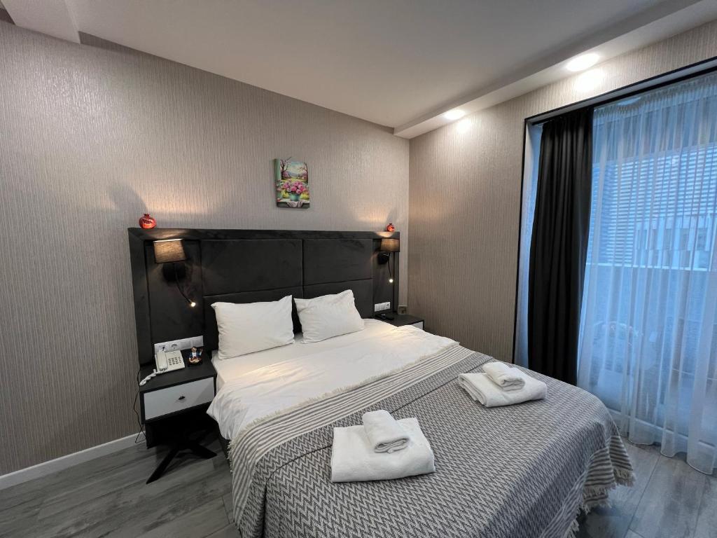 a bedroom with a large bed with towels on it at alliance panorama Batumi in Batumi