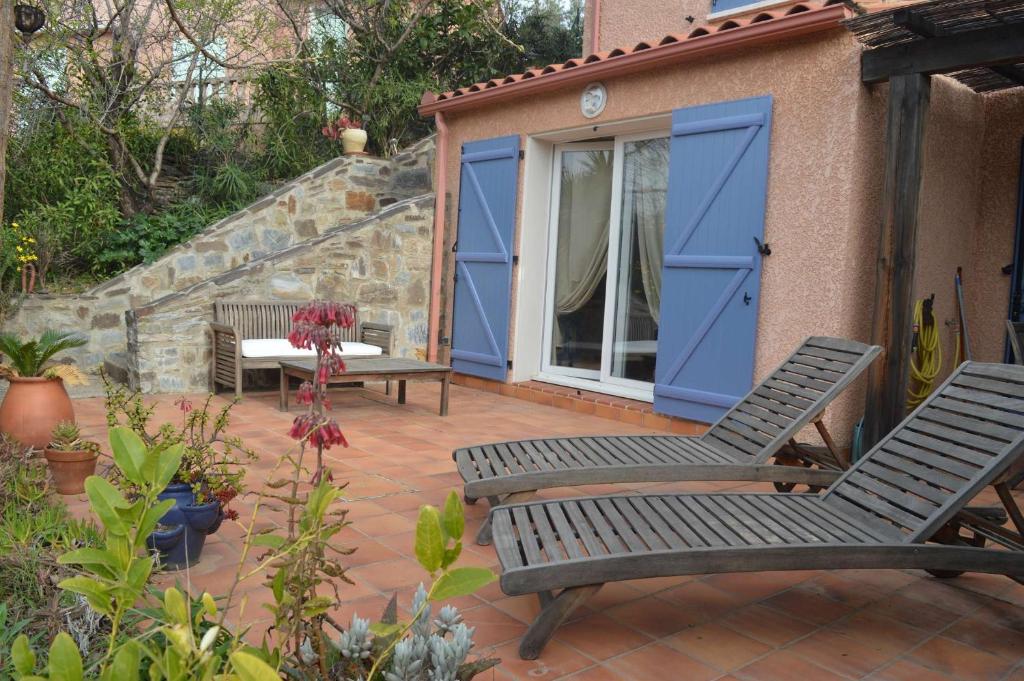 d'une terrasse avec 2 chaises et une porte bleue. dans l'établissement Maison 3 pièces 5 couchages BANYULS SUR MER BN000-08A, à Banyuls-sur-Mer