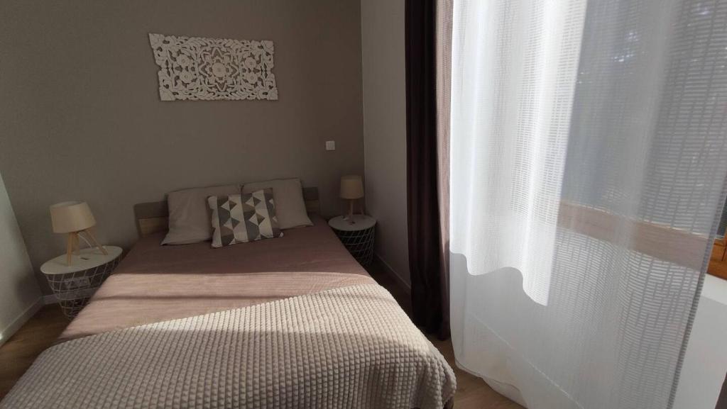 Soultz-Haut-RhinにあるStudio L'epicea Climatisation Sejour Parfaitのベッドルーム1室(ベッド1台、テーブル2台、窓付)