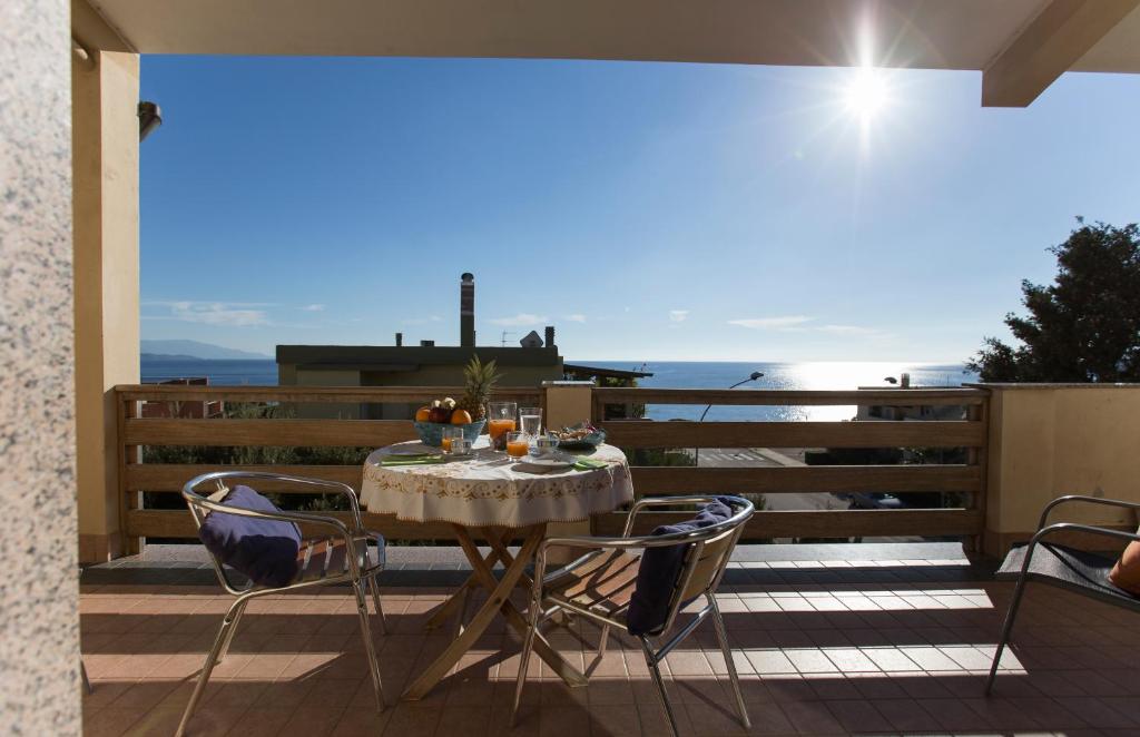 una mesa en un balcón con vistas al océano en Elena House en Alghero