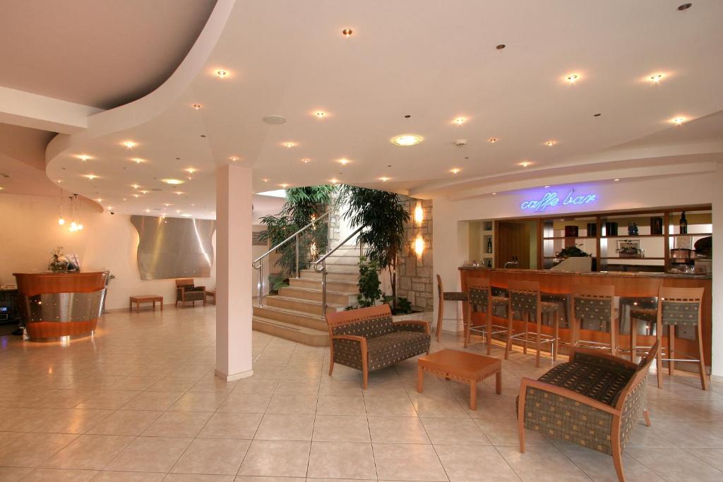 a lobby with a bar and a restaurant at Hotel Flores in Poreč