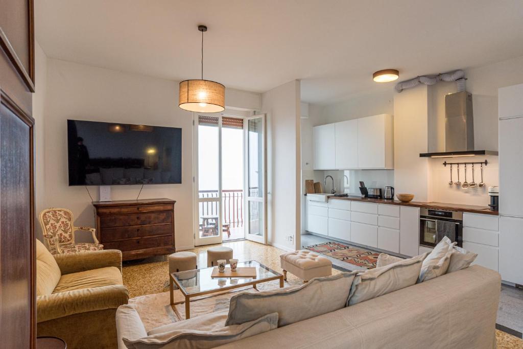 a living room with a couch and a kitchen at Bright and scenic flat 7km from Bellagio downtown in Civenna