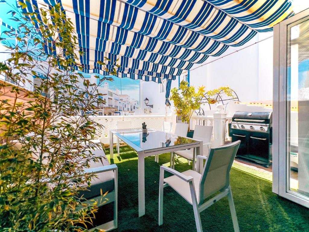 una sala da pranzo con tavolo e sedie su un balcone di Ulises La Perla a Calahonda