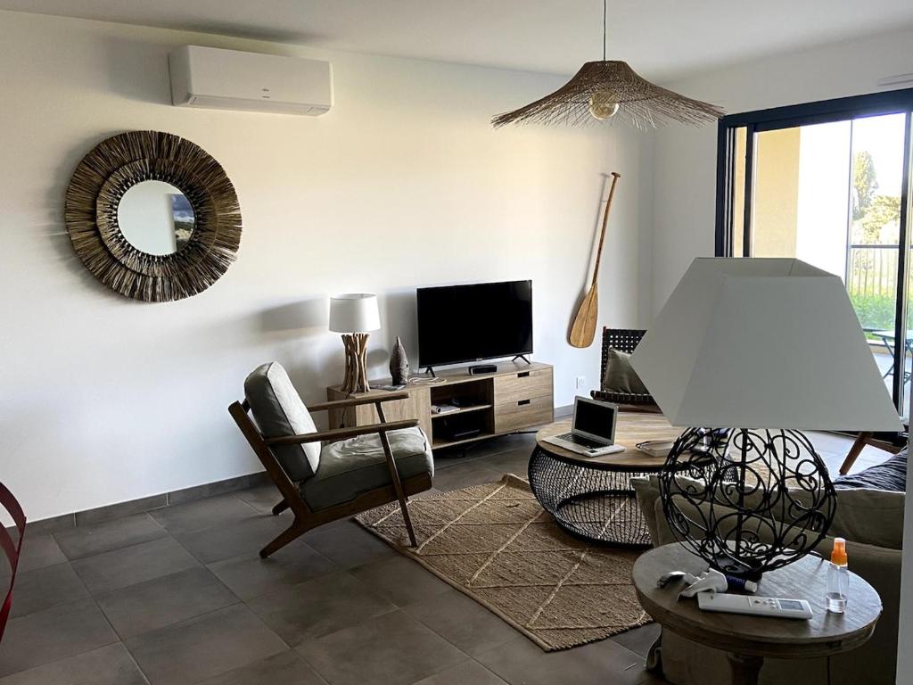 un salon avec un canapé et une télévision dans l'établissement Elégant appartement T3 sur le golfe du Valinco, à Propriano