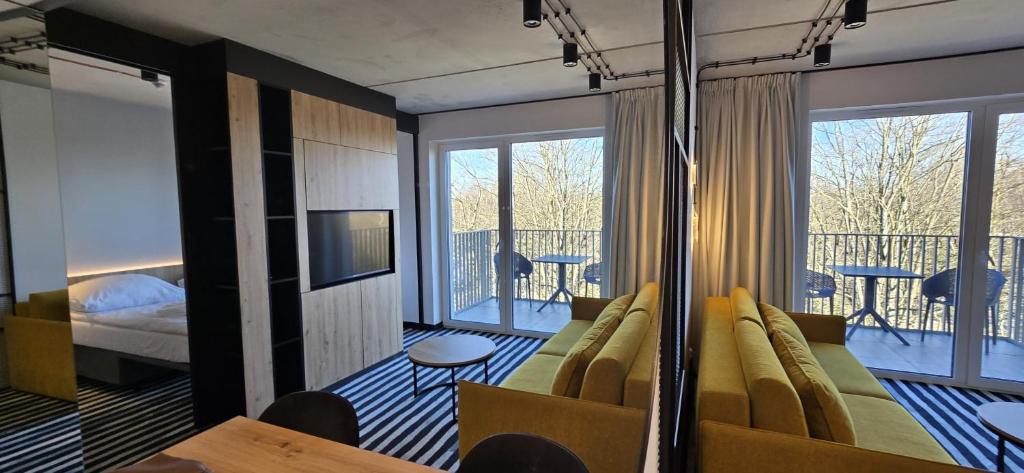a hotel room with a couch and a balcony at Green Port Spa&Wellness Rent Partners in Kołobrzeg