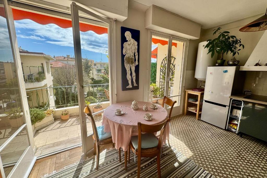 une salle à manger avec une table et une grande fenêtre dans l'établissement Beautiful T2 with balcony near downtown, à Nice