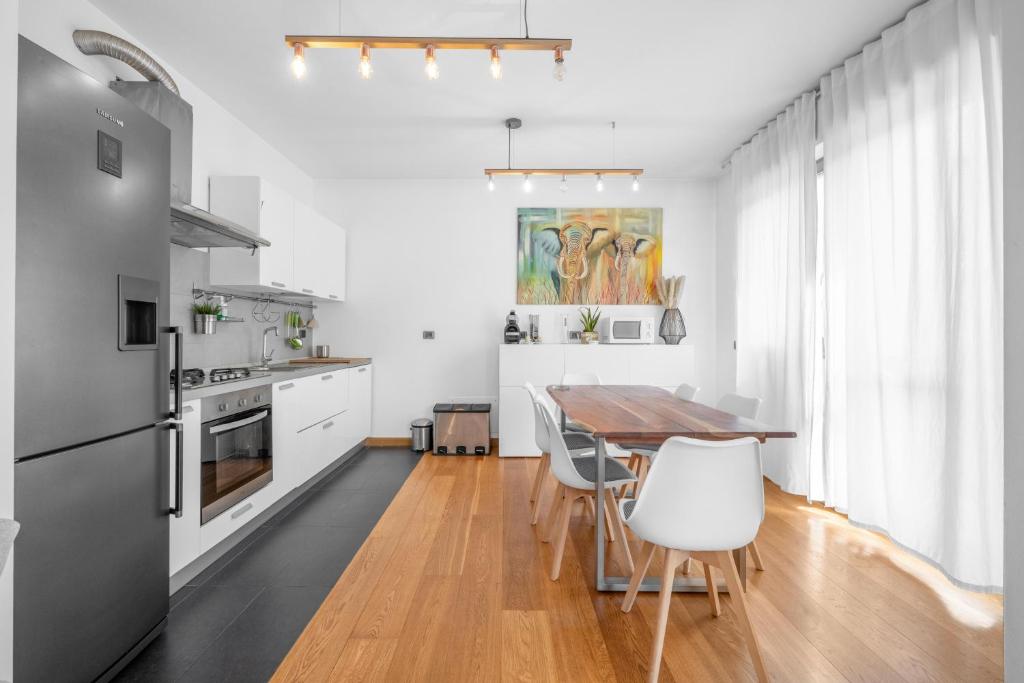 a kitchen with a wooden table and white appliances at Milano-Rho Fiera Exclusive stay private parking in Rho