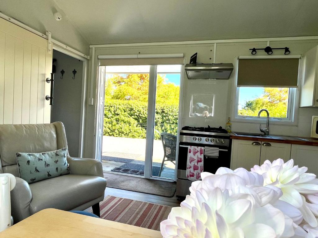 a kitchen and living room with a stove and a couch at Blackbird Cottage in Lincoln