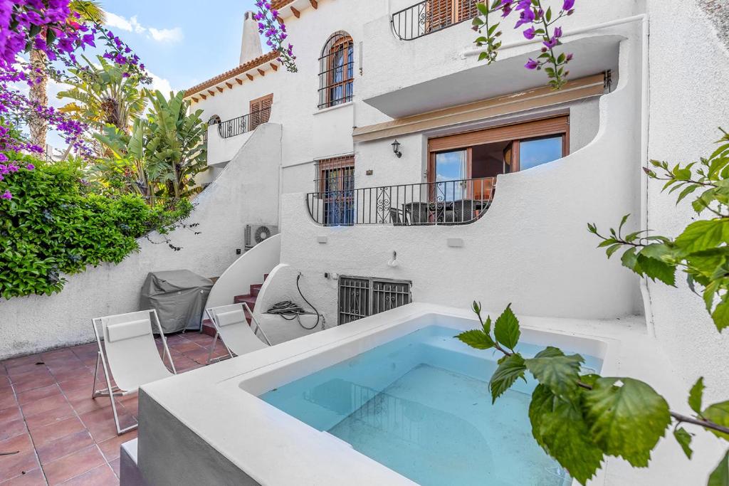 Un patio con piscina en un edificio. en Amazing bungalow with AC and private pool - reformado febrero 2025, en El Campello