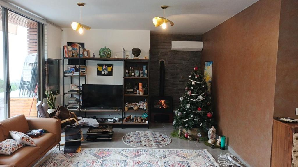 a living room with a christmas tree in a living room at Cozy Quiet escape from the City in Fatqā