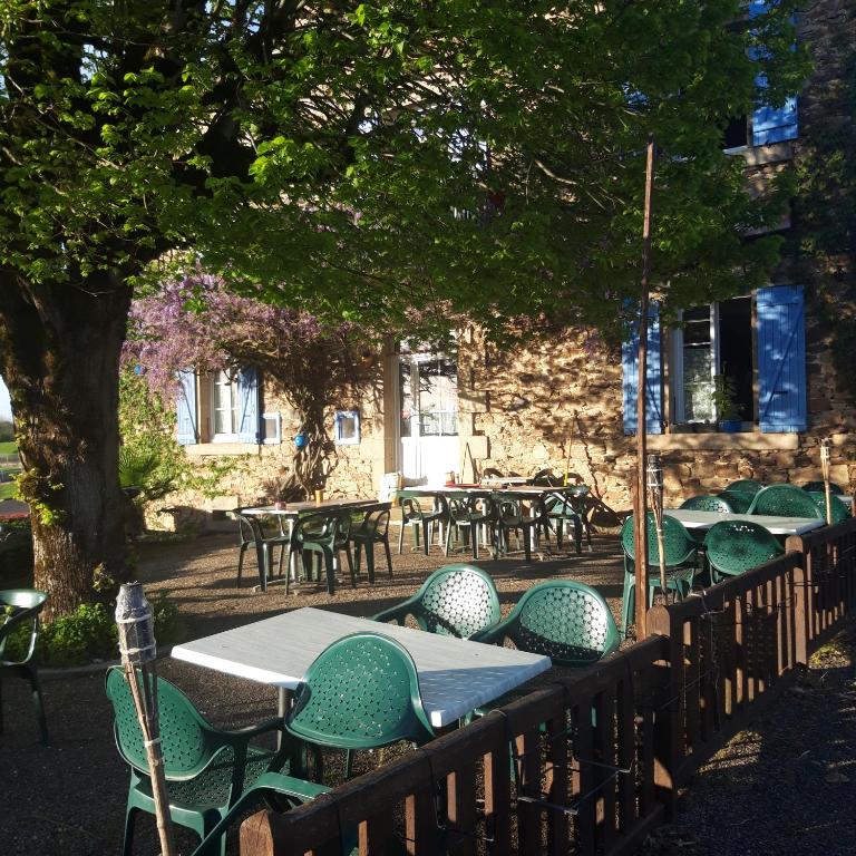 a group of tables and chairs in front of a building at chambre dhote condat sur ganaveix in Condat-sur-Ganaveix