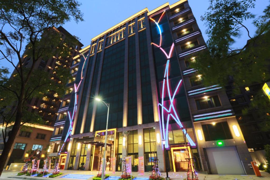 a building with lights on the side of it at Happiness Inn Hotel in Xinzhuang