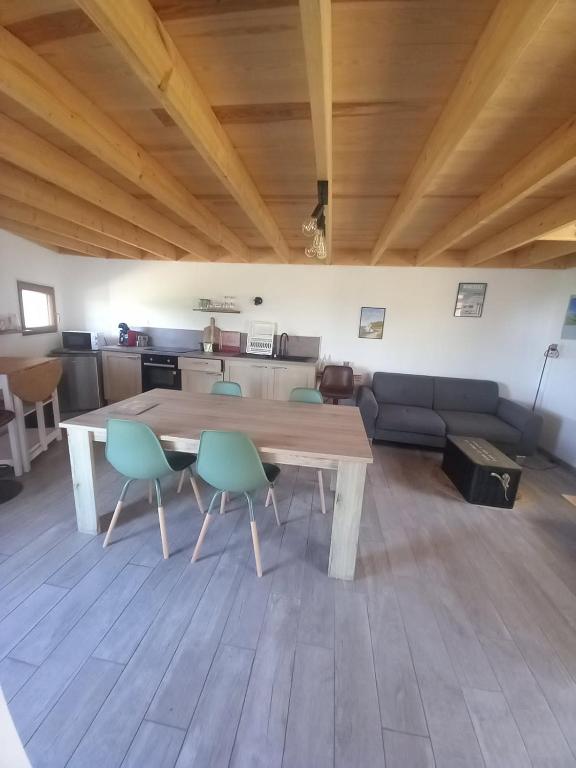 une grande table en bois dans une pièce avec des chaises dans l'établissement le lubermiga, à Wimille