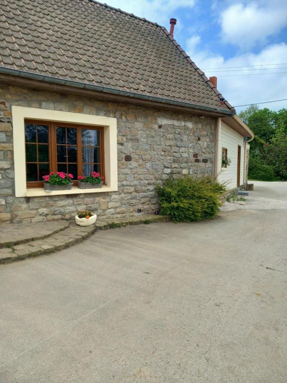 a stone house with a window with flowers on it at le lubermiga in Wimille