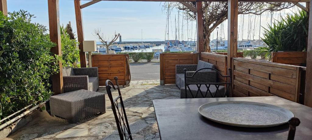 a patio with a table and chairs and a view of a harbor at La marine in Rogliano