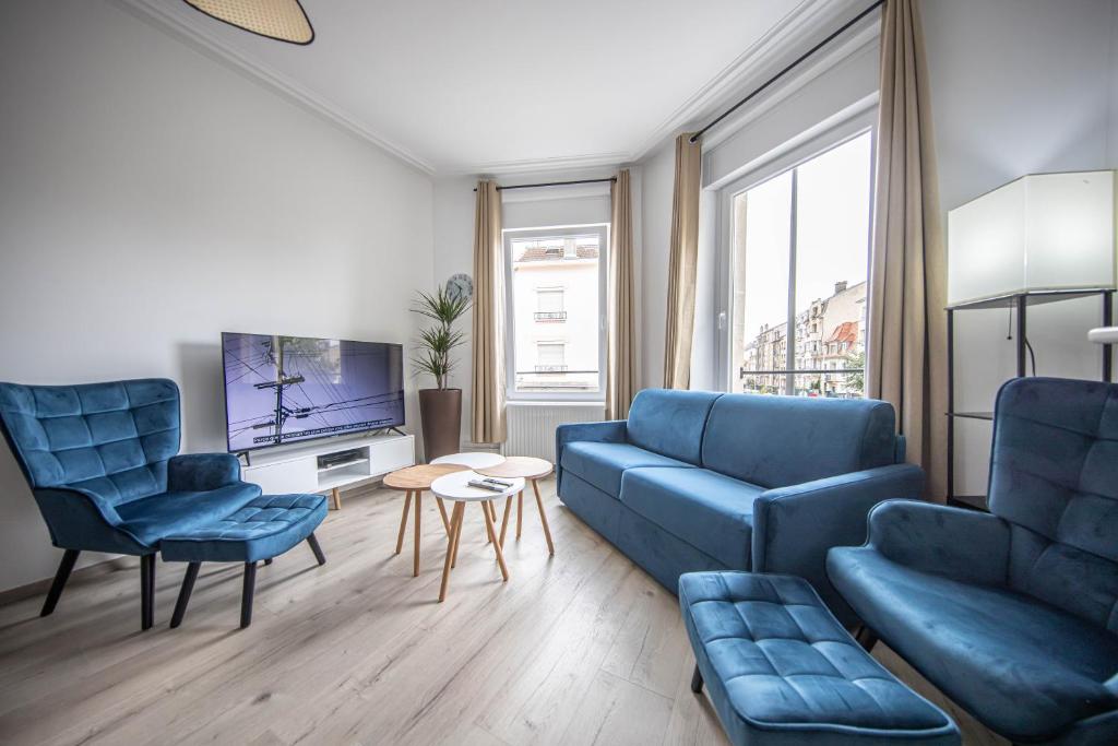 Il comprend un salon doté d'un mobilier bleu et d'une télévision. dans l'établissement Le Blue Chic - Nancy Thermal, à Nancy