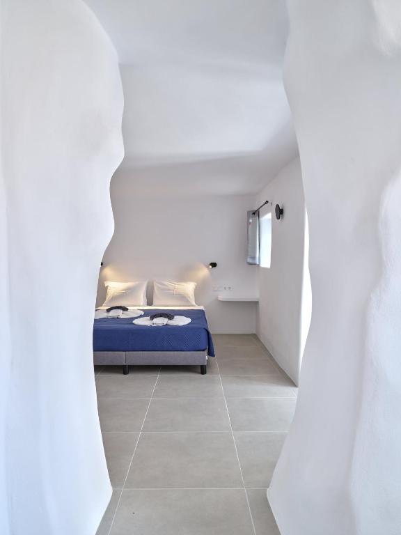 a bedroom with a blue bed in a white room at Lefkes Blissful Home in Lefkes