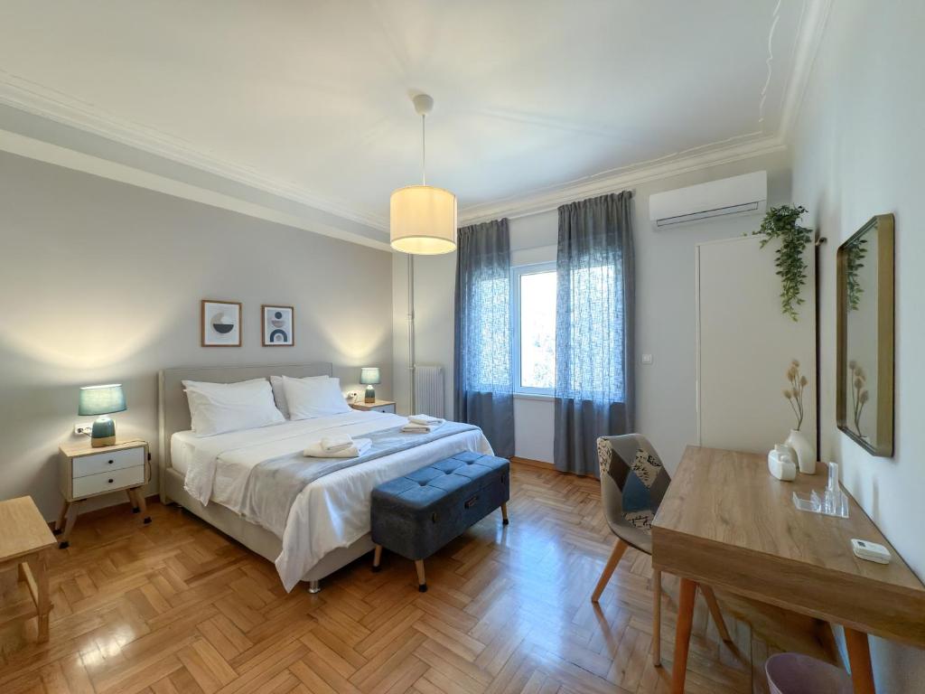 Un dormitorio con una cama, un escritorio y una mesa. en Acropolis view 4 bedroom flat, en Atenas