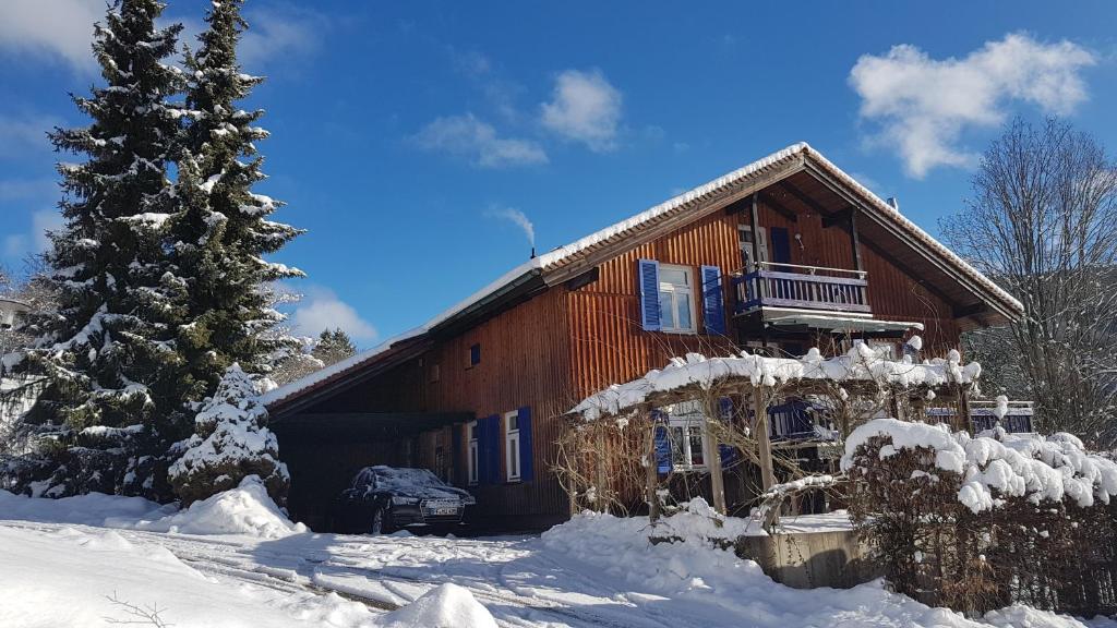 a log cabin in the snow with a christmas tree at Kuckucksnest - Ferienwohnung mit Traumblick im Schwarzwald in Bad Wildbad