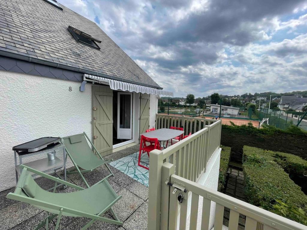 un patio avec deux chaises et une table sur un balcon dans l'établissement Duplex avec terrasse à 10 minutes à pied de la plage, à Villers-sur-Mer