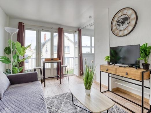 un salon avec une télévision à écran plat et un canapé dans l'établissement Le Coin Parfait l Partner Loc, à Antony