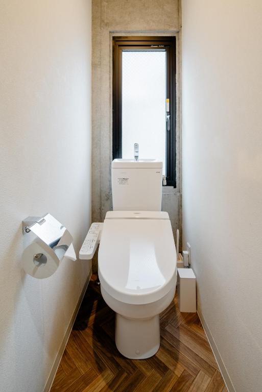 a white toilet in a bathroom with a window at 原田屋Hotel 3F in Tokyo