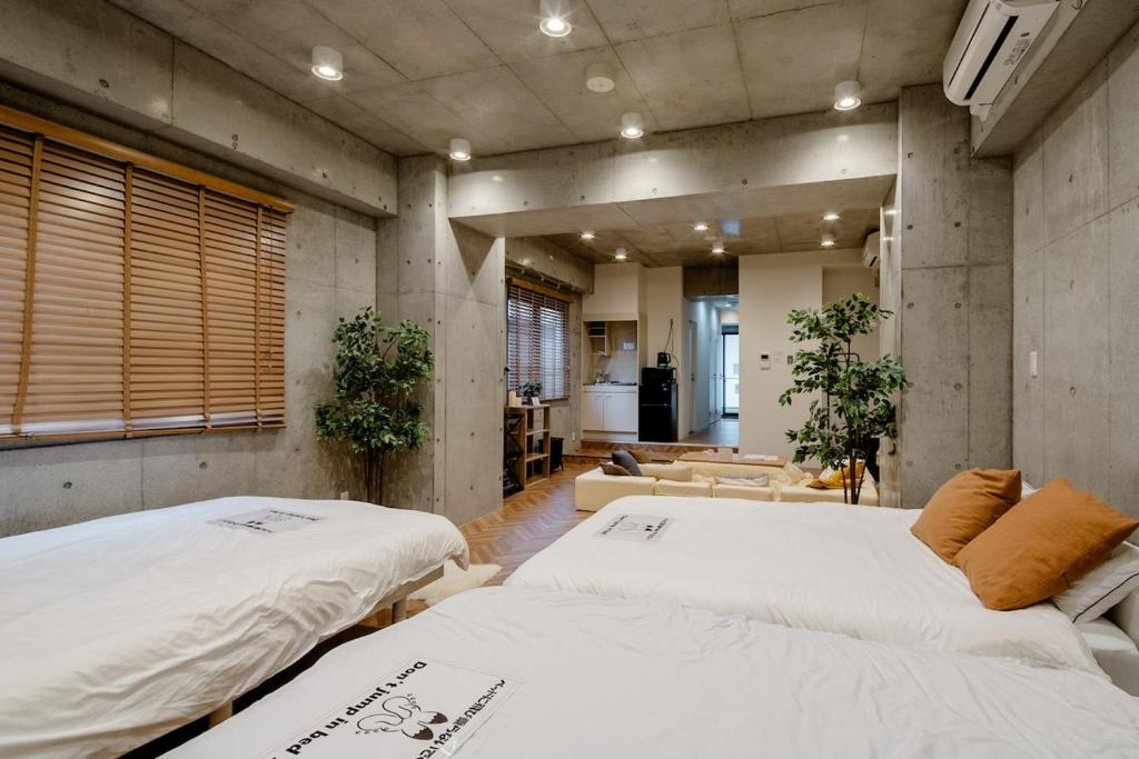 a room with two beds and a living room at 原田屋Hotel 3F in Tokyo