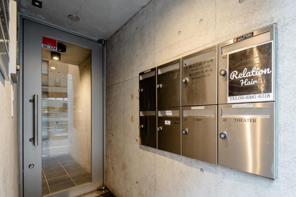 a row of lockers on a wall in a building at 原田屋Hotel 3F in Tokyo