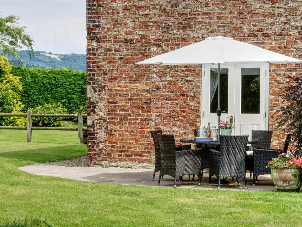 een tafel en stoelen met een parasol in de tuin bij Beaver Cottage in Thirsk