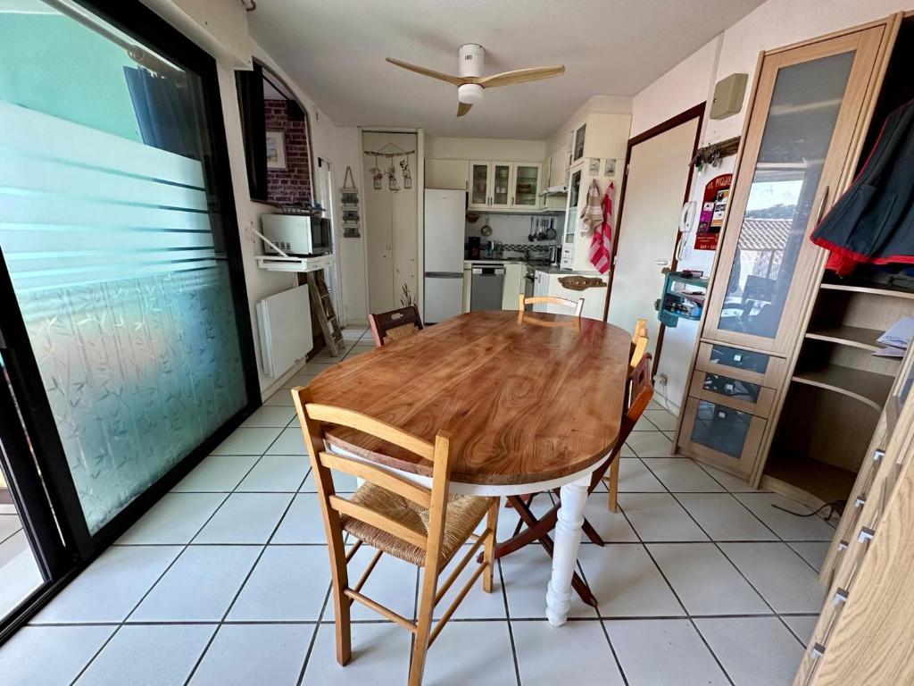 une cuisine avec une table et des chaises en bois dans l'établissement Studio centre-ville, à Capbreton